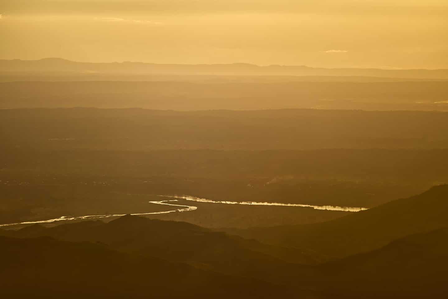 Family travel to Africa, a view of the landscape around Fisherman's Rest Lodge with a golden sky and the Shire River reflecting the sunlight arcing through the Shire Valley
